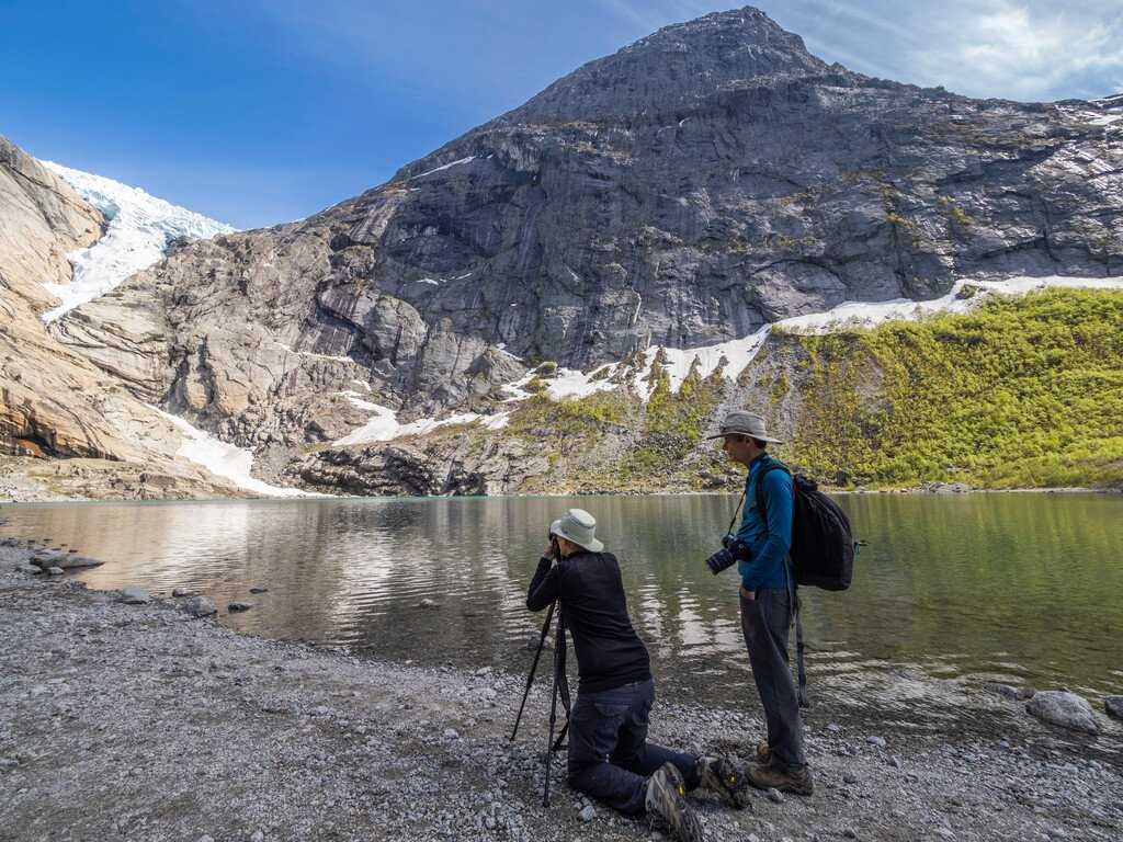 A photographer takes a photo of a fjord in Svalbard, Norway