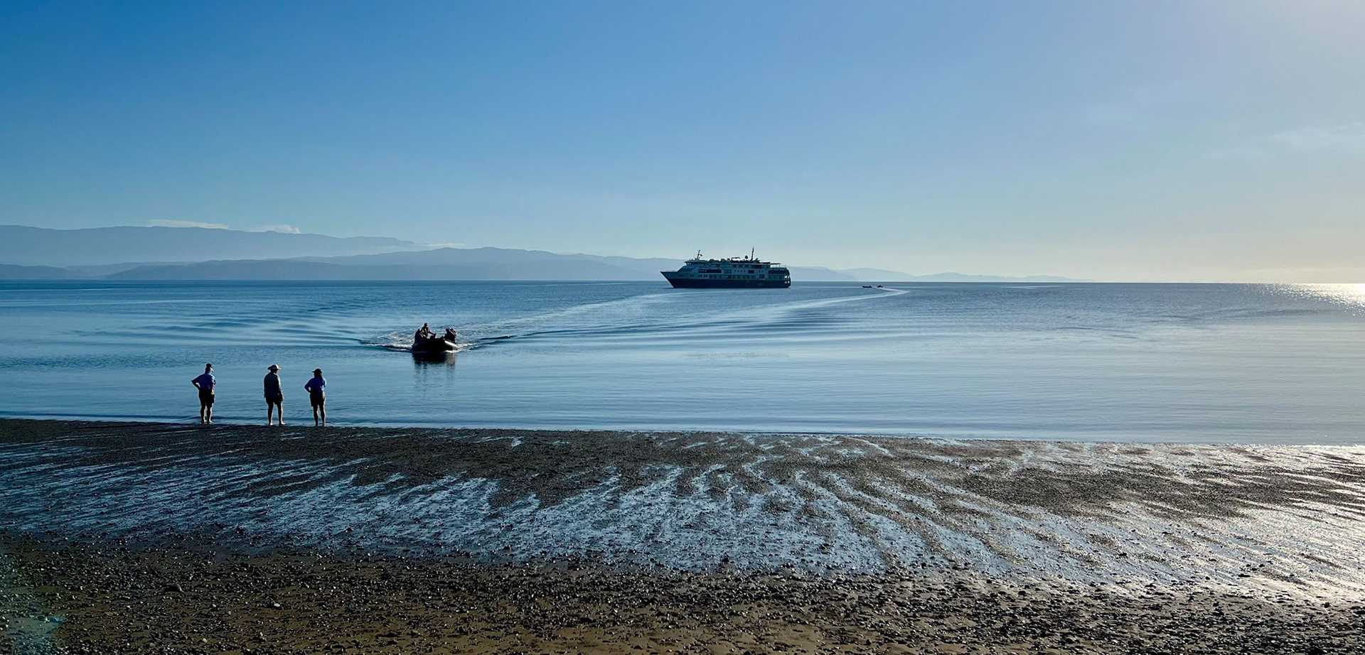 beach with a ship anchored offshore